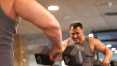 Close-up of a hand lifting a dumbbell with blurred reflection of a man doin.. Stock-Footage 344052800