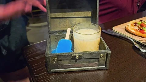 Close-up of a hand lifting the lid of a treasure chest style drink box Stock Footage 343720274