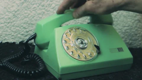 Close up of a hand lifting the receiver of a vintage green rotary telephone Stock-Footage 337006931