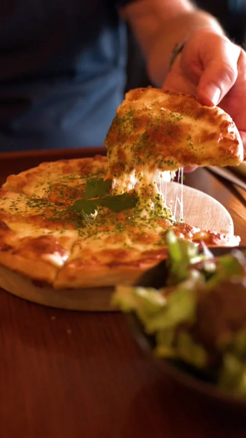 Close Up of Hand Lifting Slice of Pizza with Cheese Pull Stock Footage 340253826