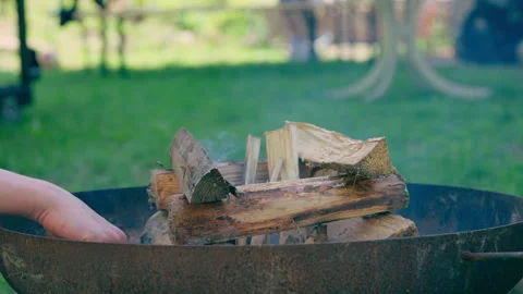 Close-Up of Hand Lighting Campfire Fire Pit with Match Stick 動画素材 338363380