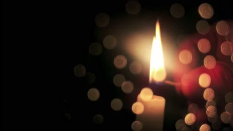 Close-up of hand lighting candle with match with bokeh effect on black 4k Stock Footage 237065737