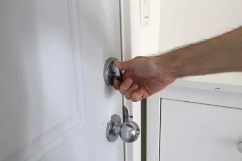 Close up hand locking door with thumb turn metal lock home safety concept Foto stock