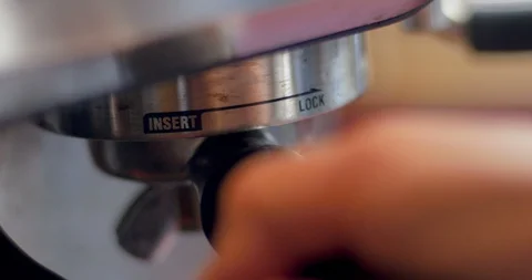 Close up of a hand locking a portafilter into an espresso machine Stock Footage 88975193