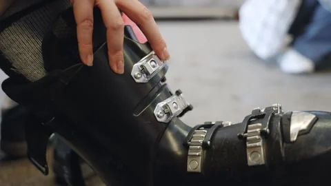 Close up on hand locking ski boot buckles in locker room in ski resort Stock Footage 261761601