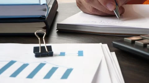 Close-up of a hand making financial records in a notebook.   Vidéo 282182564