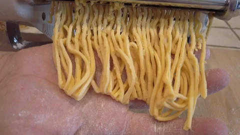 Close up hand making homemade uncooked long pasta tonnarelli (like spaghetti) Stock Footage 128773011