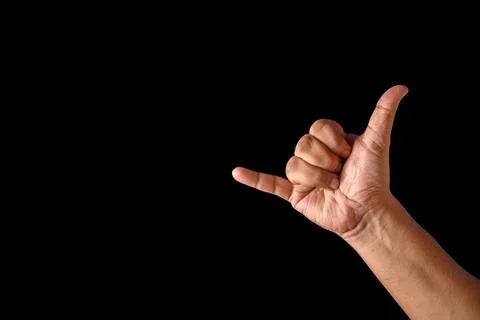 Close-Up of Hand Making Shaka Gesture with Black Background Stock Photos