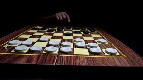 Close-up of a Hand Making a Strategic Move on a Checkerboard, Planning the Next  Видео 330434879