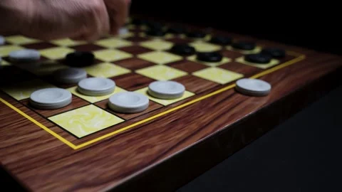 Close-up of Hand Making a Strategic Move in a Game of Checkers, Capturing an Opp Stock Footage 330435098