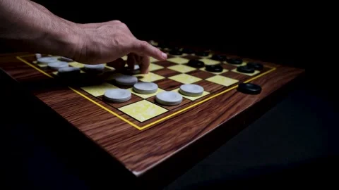 Close-up of Hand Making a Strategic Move in a Game of Checkers, Capturing an Opp Stock Footage 330435146