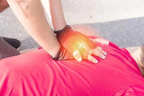 Close up hand of man gesture First Aid Emergency CPR on a Man wearing red shi Foto stock