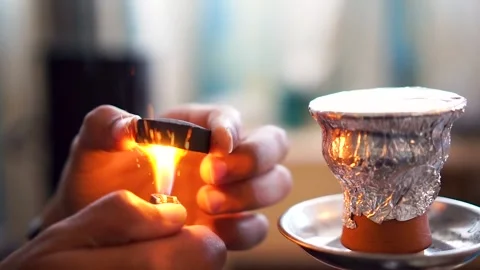 A close up hand of a man lonely is putting coal cubes on a tobacco bowl Stock Footage 146441568