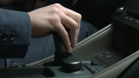 Close up on hand of man in suit shifting gear in car Vidéo 124243463