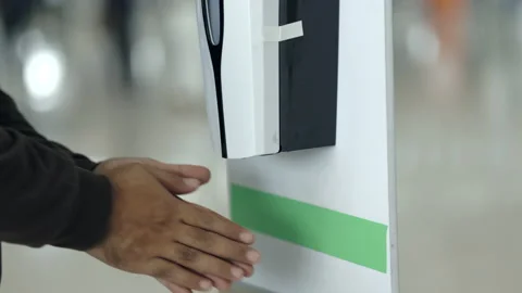 Close up hand man taking automatic spray alcohol hand washing at airport. Stock Footage 159522327