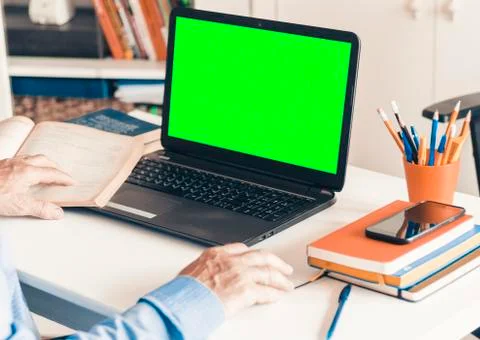 Close-up of hand man using a mouse and typing on green screen laptop on white Stock Photos