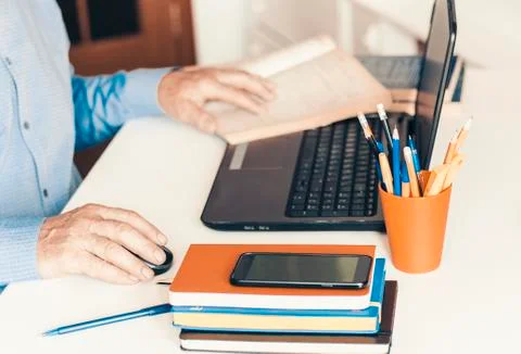 Close-up of hand man using a mouse and typing on laptop on white table, busin Stock Photos