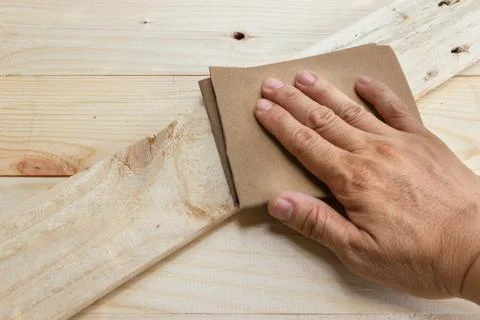 Close-up Hand of Man using sandpaper polished wooden. 스톡 사진