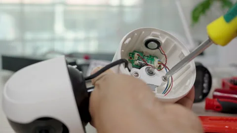 Close-up hand of man using screwdriver to repairing a wireless CCTV camera. Stock Footage 326300083