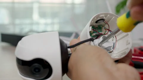 Close-up hand of man using screwdriver to repairing a wireless CCTV camera. Stock Footage 326300437