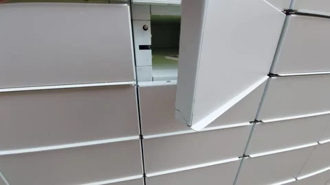 Close-up of a hand manually closing an empty locker door of an automated parcel Stock Footage 338283227