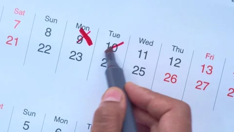 Close up hand marking calendar dates with red pen showing schedule planning.. Stock Footage 332578547