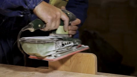 Close-up of the hand of the master carpenter grind the product of chestnut wood. Vidéo 100806172