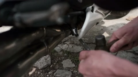 Close up of hand of a mechanic screw some screws of a motorcycle in a garage Stock Footage 152098036
