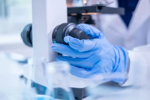 Close-up hand microscope equipment in virus epidemic analysis experiment re.. Stock Photos