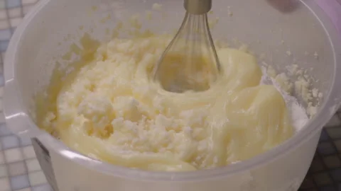 Close-up, hand mixer beating cream ingredients in plastic bowl on kitchen Stock Footage 308881965