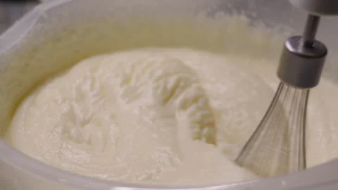Close-up, hand mixer whipping cake buttercream in plastic bowl Видео 337118095