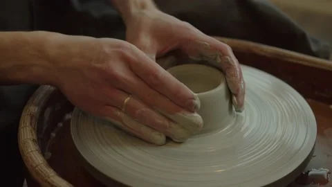Close up hand modeling pottery on a potter wheel in a cozy home workshop. Creati Video stock 236202294