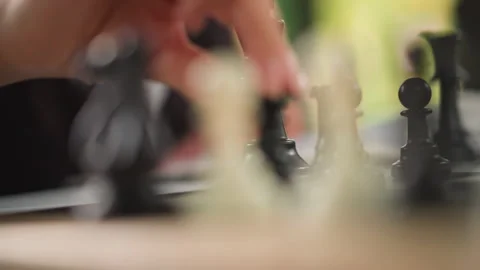 Close up hand moves black and white chess pieces across wooden board in Stock-Footage 346649925