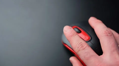 Close-up of a hand moving a black and red wireless mouse on a clean dark desk 스톡 동영상 331467471
