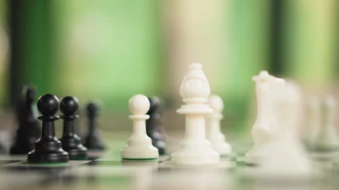 Close up of hand moving chess pieces on board with alternating colors and soft Stock-Footage 346649733