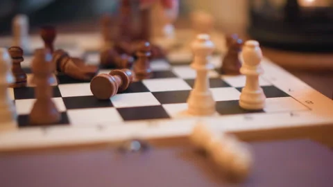 Close up of hand moving chess pieces on wooden board with soft lighting and Stock-Footage 346730107
