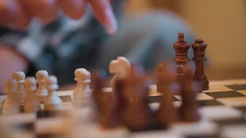 Close up hand moving chess pieces on wooden board with shallow depth focus Stock-Footage 346730125