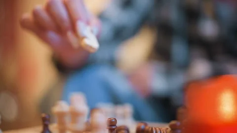 Close up hand moving chess pieces on board with warm orange background Stock-Footage 346730145