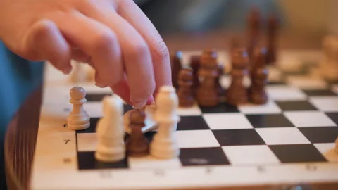 Close up of hand moving chess pieces on checkered board with focused pawns and Stock-Footage 346736151