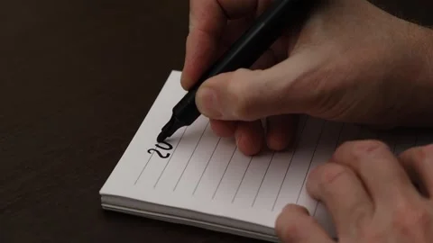 Close up hand in notebook writes numbers new year 2025 pen and emphasizes them. Stock Footage 303137442