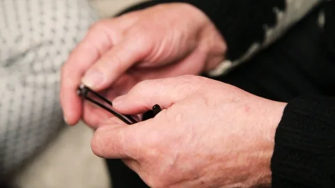 Close up hand old man hold glasses at home elder family finger lifestyle love Stock Footage 99803258