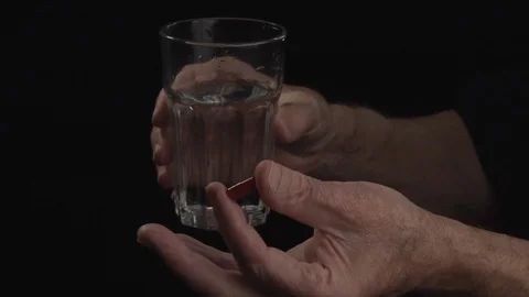 Close up. Hand of old man holding a pill on black background Video stock 105963230