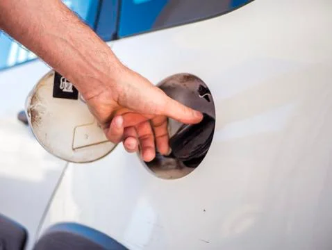 Close up hand open and close gas tank cap white car to fill it with fuel Stock Photos