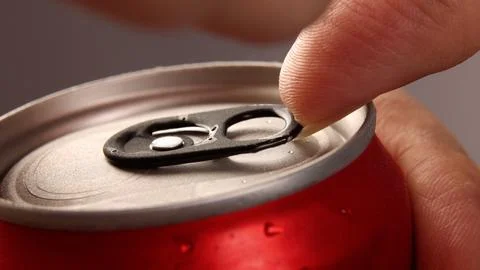 Close up of hand open cola or soda beverage can with pull tab. Stock Photos