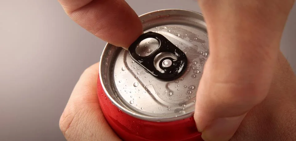 Close up of hand open cola or soda beverage can with pull tab. Stock Photos
