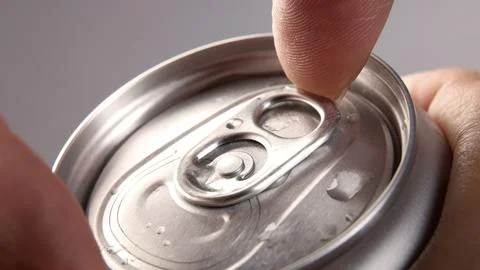 Close up of hand open cola or soda beverage can with pull tab. Stock Photos