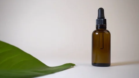 Close up of a hand opening a bottle of CBD or any other essential oil - white Stock Footage 122693113