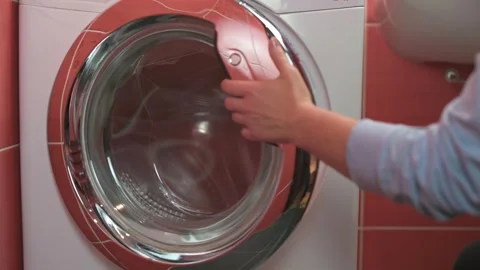 Close-up hand opening door of front-load washing machine. scene features modern Vídeo Stock 294295551