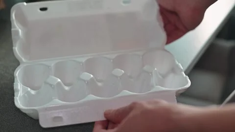 Close-up of hand opening empty egg carton and removing lid, poverty Stock Footage 339096237