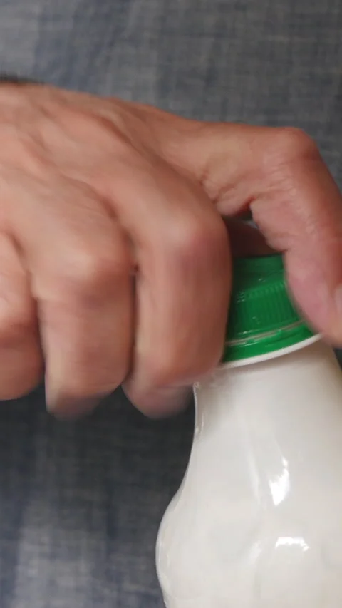 Close-Up Of A Hand Opening A Green-Capped White Plastic Bottle Stock Footage 304418285